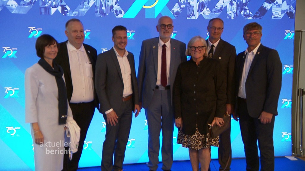 Foto: Eine Gruppe von Menschen posiert vor einer Fotowand