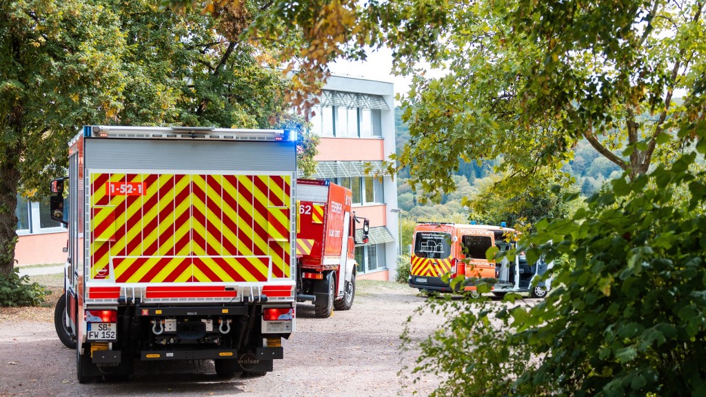 Einsatzkräfte von Feuerwehr und Rettungsdienst stehen in der Nähe des Einsatzortes. Ein Kind ist in Sulzbach in einen Schacht gerutscht.