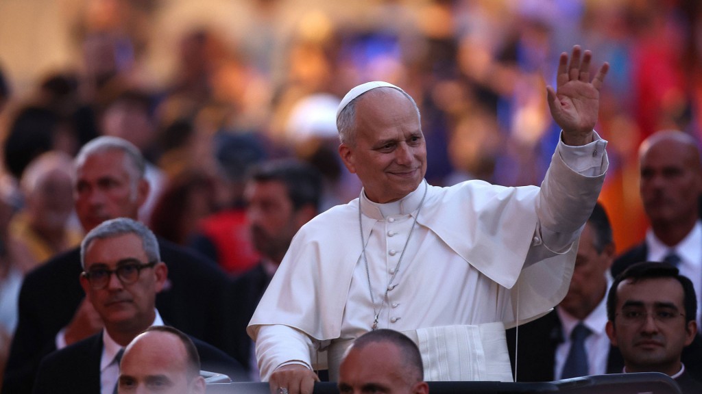 Papst Leo XIV. winkt einer Menschenmenge zu.