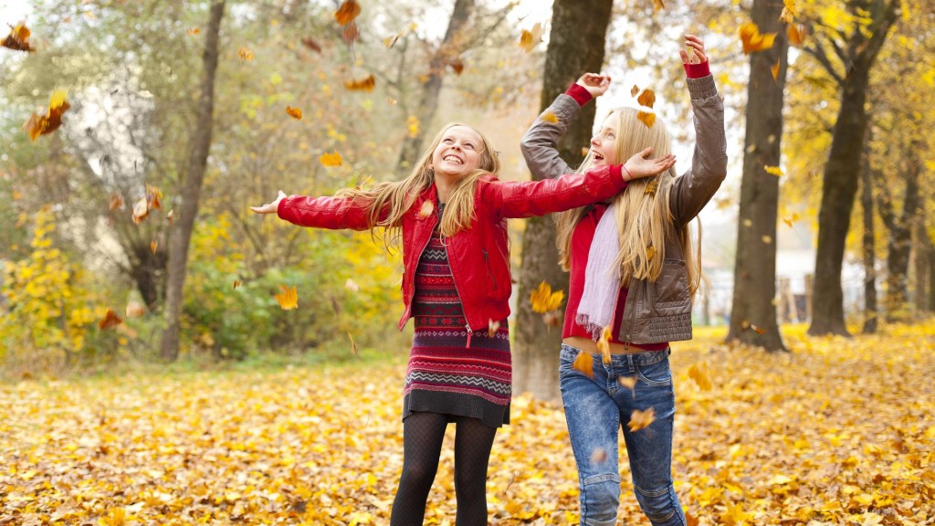 Kinder spielen mit Herbstlaub
