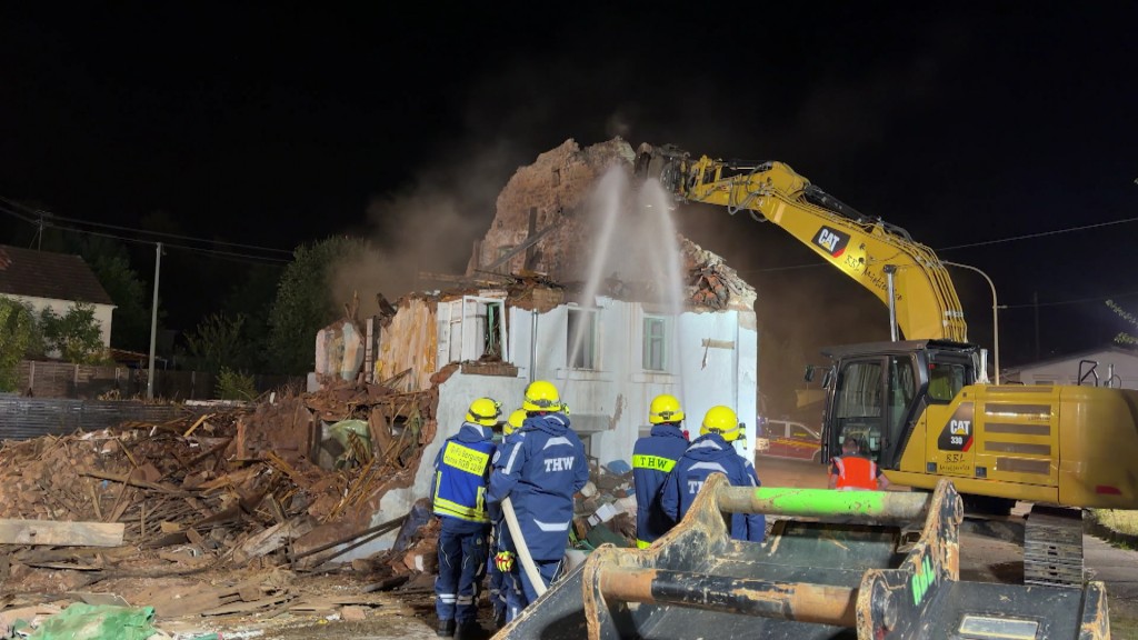 Foto: Mitarbeitende der Feuerwehr bei einem Einsatz bei einem eingestürzten Haus