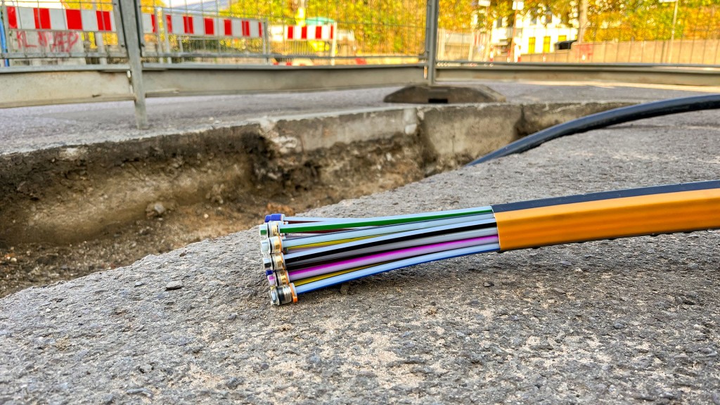 Glasfaserkabel liegen in einem Baustellengraben