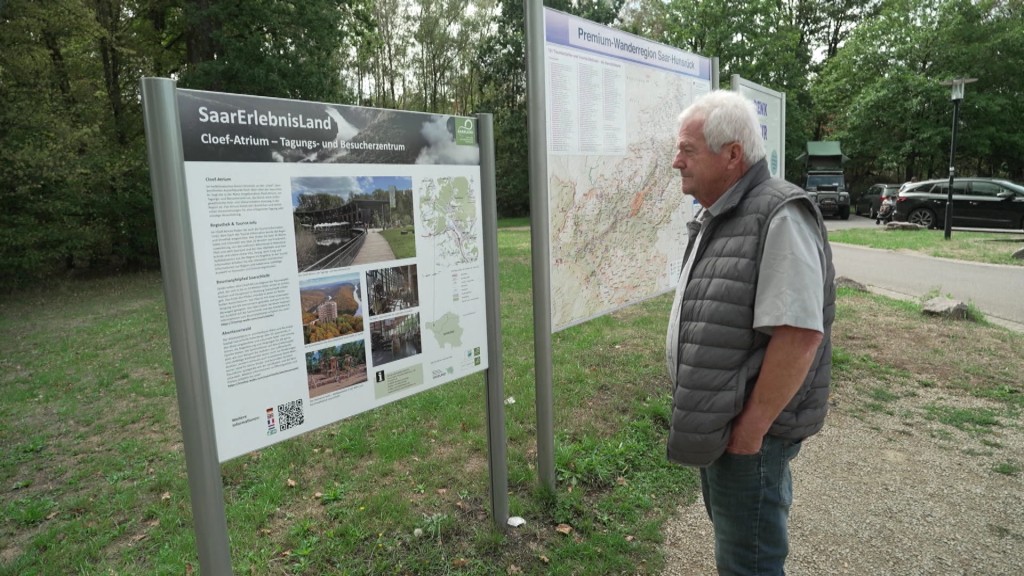 Foto: Mann vor Plakat in Orschholz