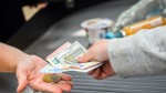 Foto: Eine Kassiererin gibt einer Kundin Wechselgeld an der Kasse eines Supermarktes