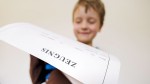 Ein Schulkind hält sein Zeugnis in den Händen
