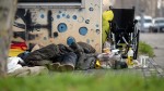 Eine vermutlich obdachlose Person liegt in der Innenstadt unter einem Schlafsack